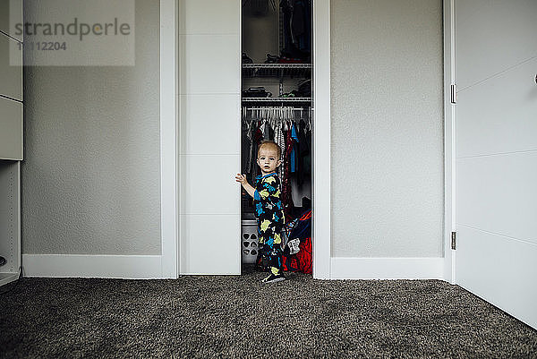 Porträt eines kleinen Jungen am Schrank stehend