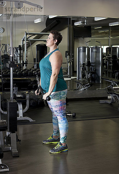 Ganzflächige Seitenansicht einer im Fitnessstudio trainierenden Frau