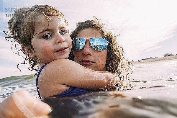Porträt von Mutter und Tochter beim Schwimmen im Meer