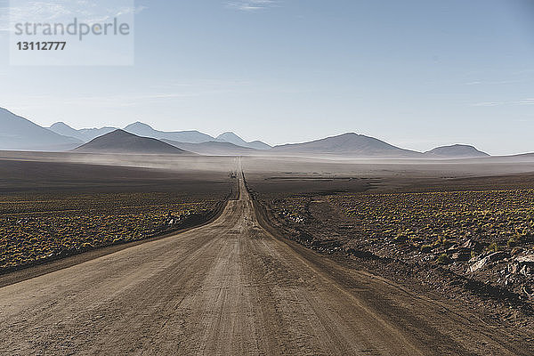 Landschaftliche Ansicht einer unbefestigten Straße inmitten der Atacama-Wüste gegen den Himmel