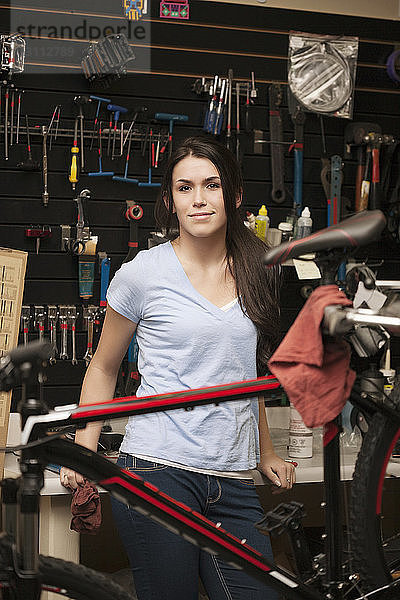 Porträt eines Geschäftsinhabers mit Fahrrad in der Werkstatt stehend