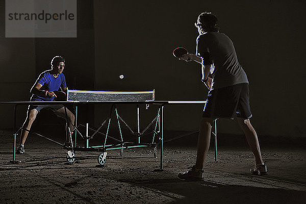 Freunde spielen nachts Tischtennis gegen Bauen