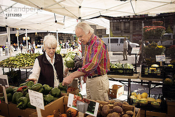 Älteres Ehepaar kauft Gemüse auf dem Straßenmarkt