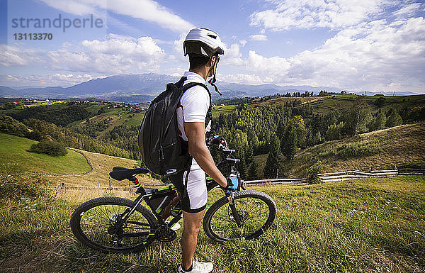 Seitenansicht eines Athleten mit Fahrrad am Berg