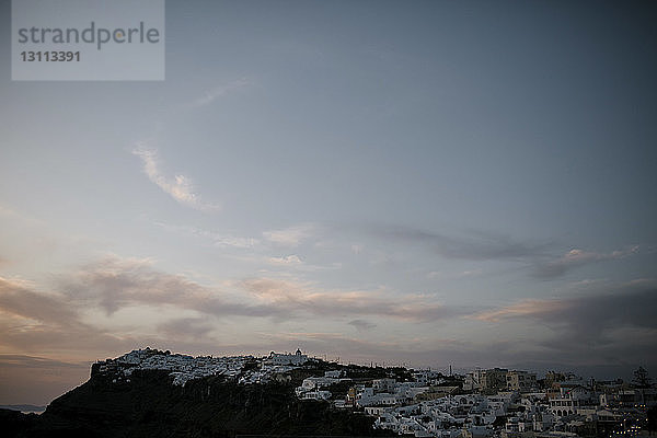 Weiß getünchte Häuser in der Stadt auf Bergen gegen den Himmel bei Sonnenuntergang