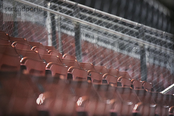 Niedrigwinkelansicht der leeren Sitze im American-Football-Stadion durch den Zaun gesehen