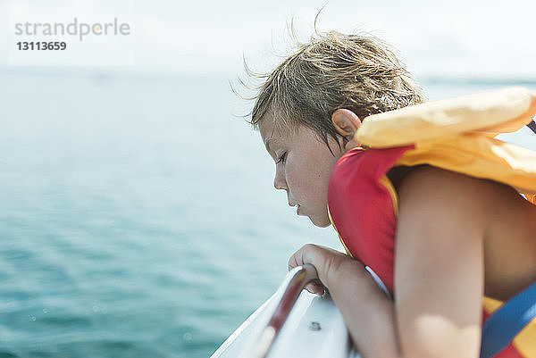 Seitenansicht eines Mädchens mit Schwimmweste  das im Boot auf dem See sitzt