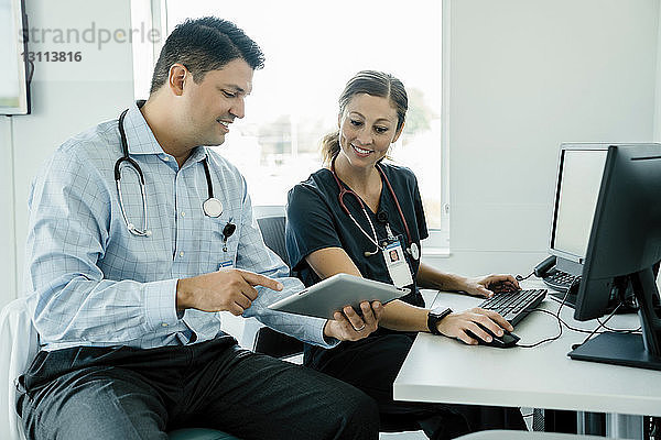 Arzt zeigt einer Kollegin im Krankenhaus einen Tablet-Computer
