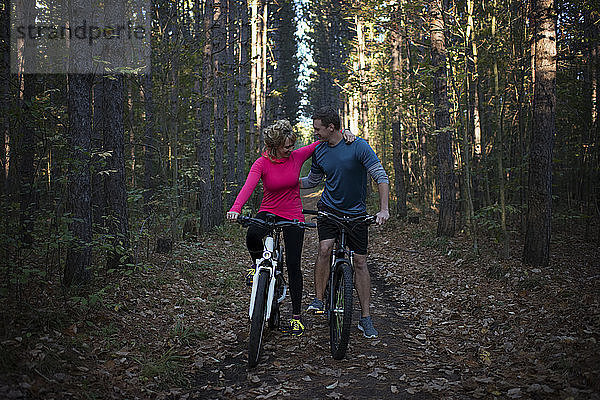 Ein Paar Mountainbiker gemeinsam gegen Bäume im Wald