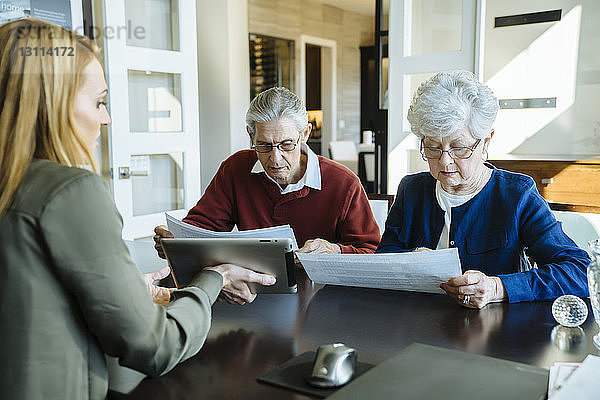 Älteres Ehepaar liest Dokumente im Büro des Finanzberaters