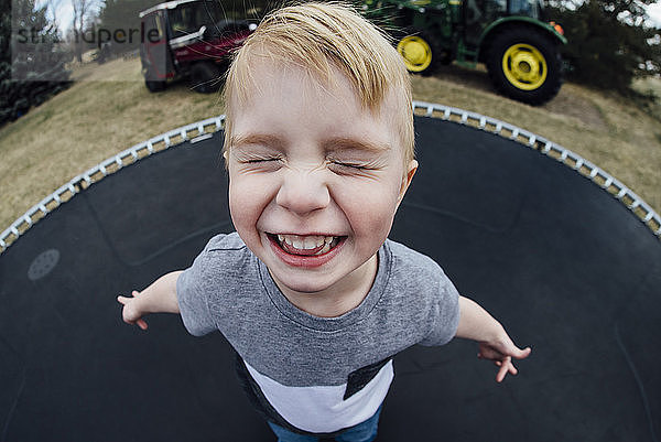 Schrägaufnahme eines fröhlichen Jungen beim Trampolinspiel