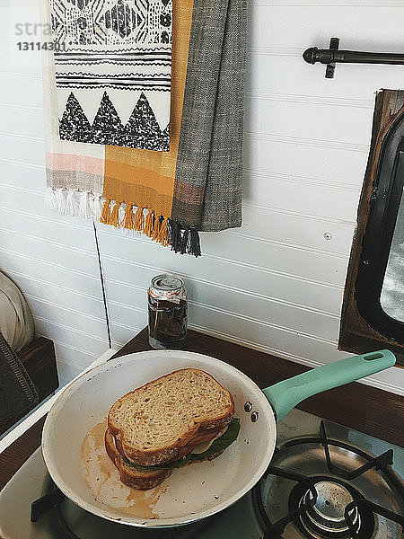 Schrägansicht auf die Kochpfanne mit Sandwich auf dem Herd im Wohnmobil