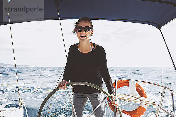 Lächelnde Frau fährt Boot auf See