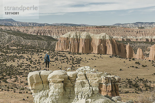 Wanderin in voller Länge auf Felsformation in der Wüste stehend