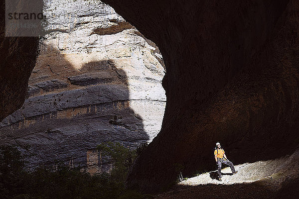 Sonnenlicht fällt auf in Höhle stehenden Mann