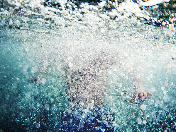 Unterwasser schwimmender junger Mann in der Mitte