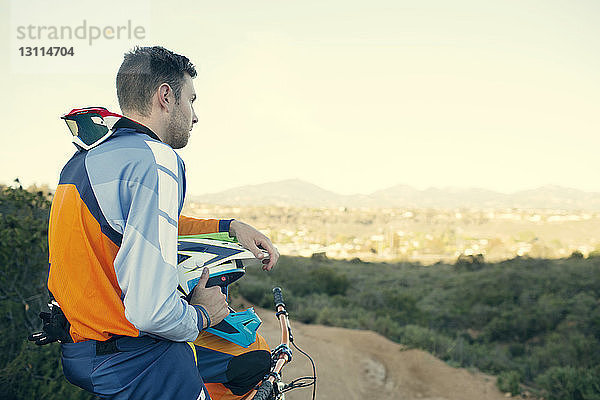 Seitenansicht eines Mountainbikers mit Blick gegen den Himmel