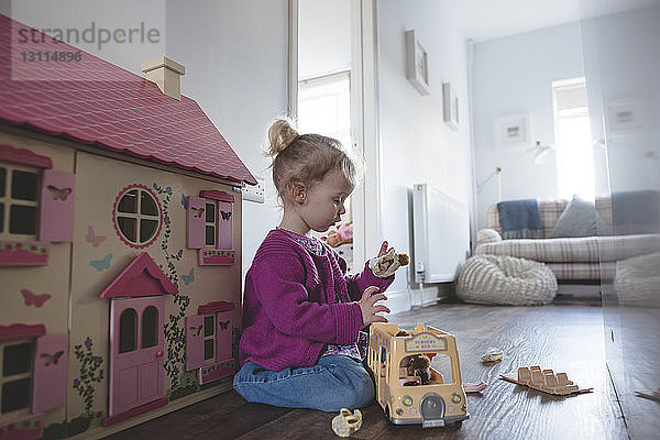 Seitenansicht eines Mädchens  das zu Hause mit Spielzeug spielt