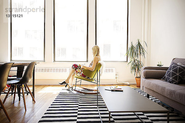 Geschäftsfrau sitzt auf einem Sessel im Kreativbüro