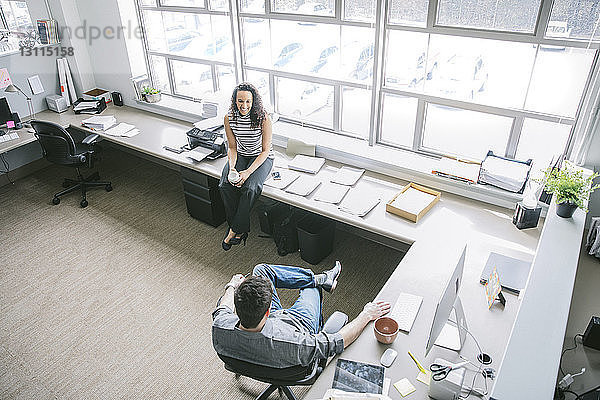 Scharfer Blick auf Geschäftsleute  die an Schreibtischen im Büro sitzen und reden