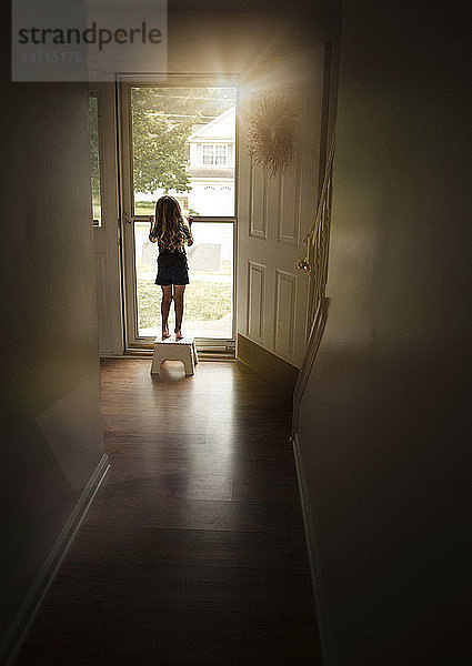 Rückansicht eines Mädchens  das zu Hause an der Tür steht