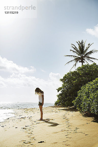 Seitenansicht einer am Strand stehenden Frau gegen den Himmel