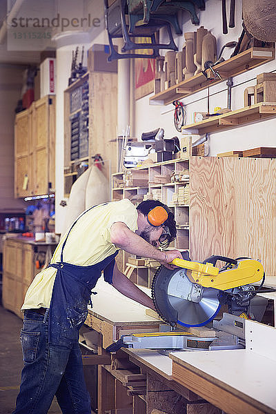 Handwerker mit Kreissäge in einer Holzwerkstatt