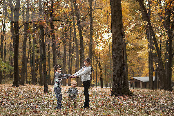 Geschwister spielen im Herbst im Park auf dem Feld