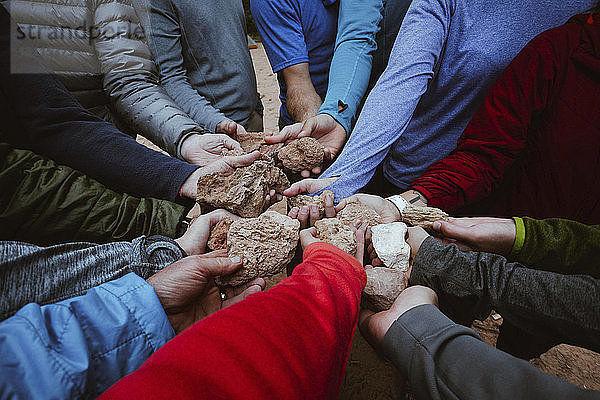 Beschnittenes Bild einer Familie  die Steine im Grand Canyon Nationalpark hält