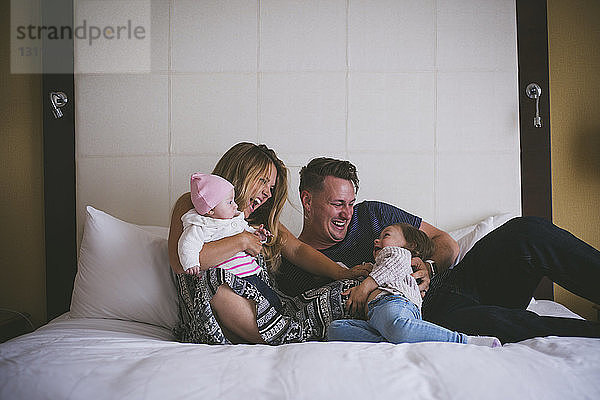 Glückliche Familie genießt zu Hause im Bett
