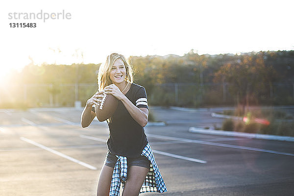 Fröhliche Frau spielt auf American-Football-Parkplatz