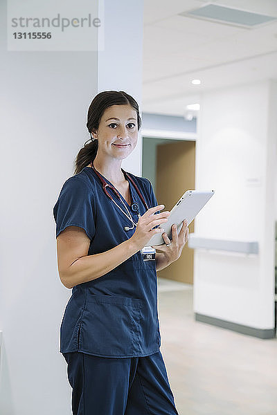 Porträt einer selbstbewussten Ärztin mit Tablet-Computer im Krankenhaus