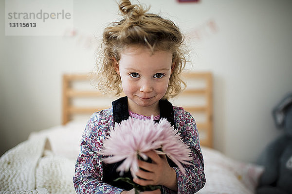 Porträt eines niedlichen Mädchens mit Gerbera im Schlafzimmer