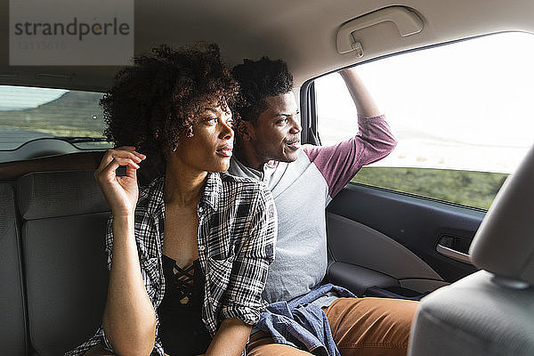 Ehepaar schaut durch ein Fenster  während es im Auto unterwegs ist