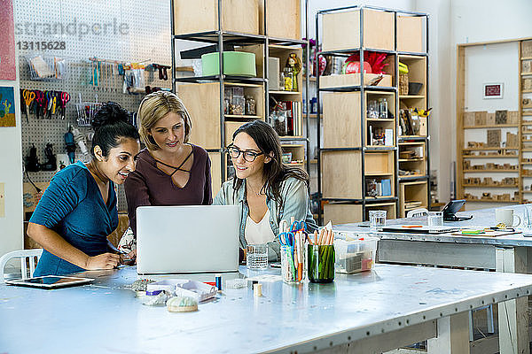 Geschäftsfrauen  die bei der Arbeit im Büro auf den Laptop schauen