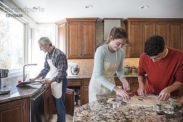 Familie bereitet zu Hause Lebkuchen in der Küche zu