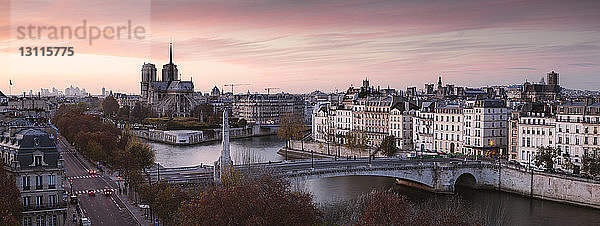 Hochwinkelansicht der Brücke über die Seine vor dramatischem Himmel bei Sonnenuntergang