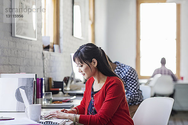 Geschäftsfrau benutzt Laptop bei der Arbeit im Büro