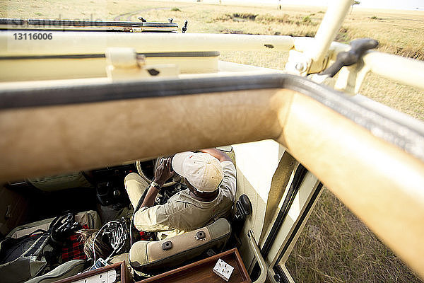 Hochwinkelaufnahme eines Mannes im Geländewagen im Serengeti-Nationalpark