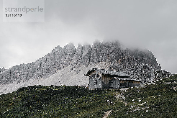 Szenische Ansicht des Hauses auf einem Hügel am Berg gegen bewölkten Himmel bei Nebelwetter