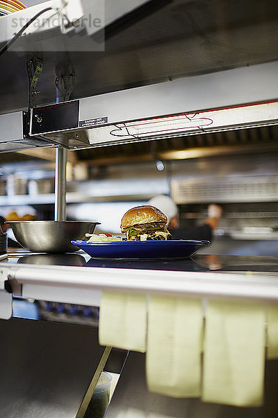 Cheeseburger im Teller auf Großküchentheke