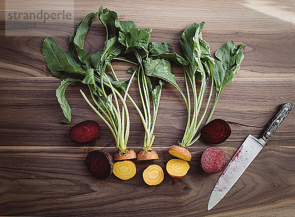 Draufsicht auf gehacktes Gemüse mit Küchenmesser auf Holztisch