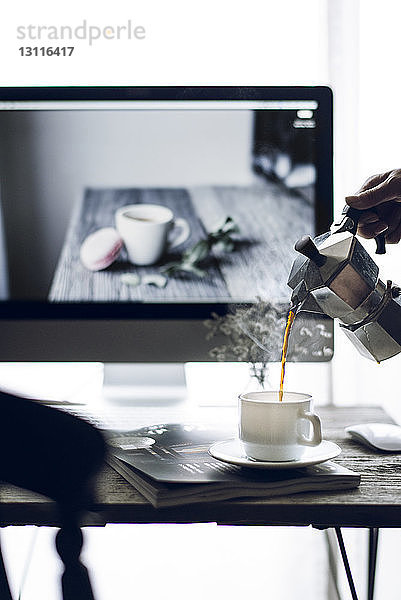 Ausgeschnittenes Bild einer Frau  die Kaffee in eine Tasse gießt