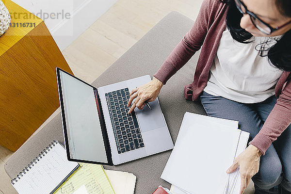 Schrägansicht einer Geschäftsfrau mit Laptop im Büro