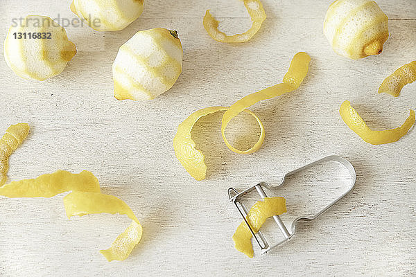 Draufsicht auf geschälte Zitronen auf Holztisch