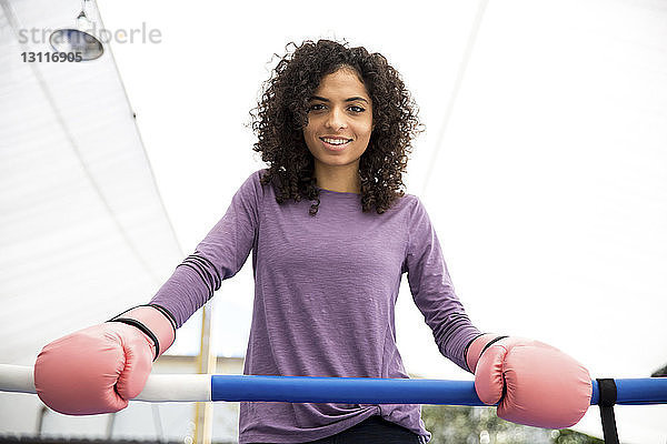 Porträt einer lächelnden Boxerin im Boxring stehend