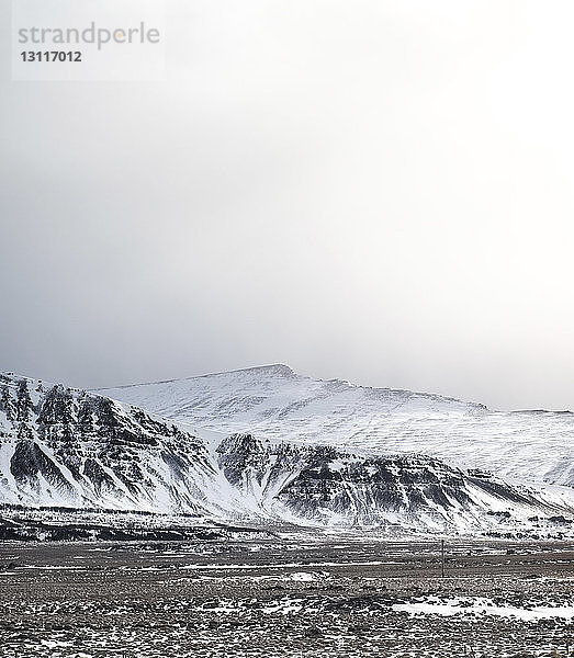 Landschaftliche Ansicht schneebedeckter Berge gegen den Himmel bei nebligem Wetter