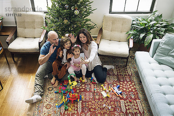 Fröhliche Familien-Videokonferenzen  während man zu Hause am Weihnachtsbaum sitzt