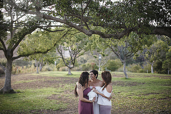 Glückliche Familie steht auf dem Feld im Park