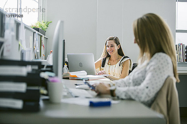 Weibliche Kollegen am Schreibtisch im Büro